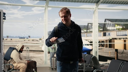 Man traveler verifying boarding pass and passport before flight departure, people with suitcases and carry-on luggage preparing for boarding plane. Authentic air travel and airline industry.