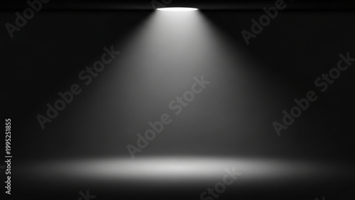 A spotlight shines down in a dark room with a single beam of light