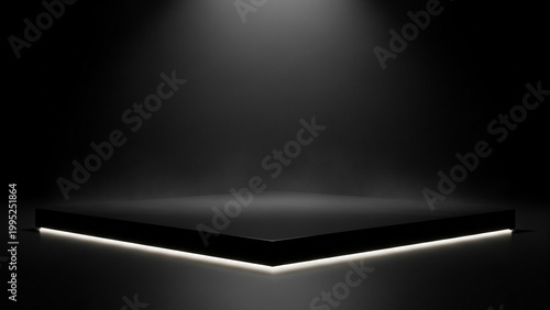 A sleek black stage with a spotlight shining down on it in a dark room