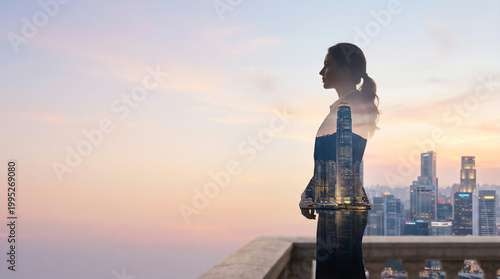 Silhouette of a businesswoman looking out over a city skyline at sunrise
