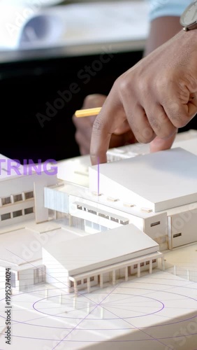 Vertical video: Designers tapping model roof, peer pointing, causing purple AR rings marking module
