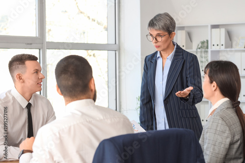 Female business consultant working with people at table in office