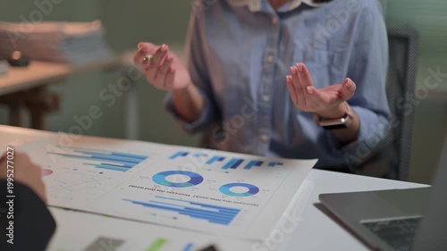 Businesswoman gesturing while explaining financial data chart