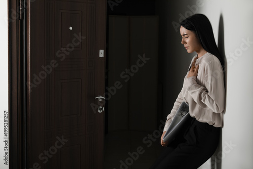 Tableau sur toile Young businesswoman with folder having panic attack in hallway at office
