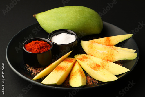 raw mango slices with chili powder and salt for tropical pickle preparation