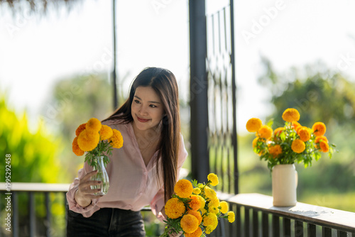 Foto Young woman arranging natural marigold flowers in a vase