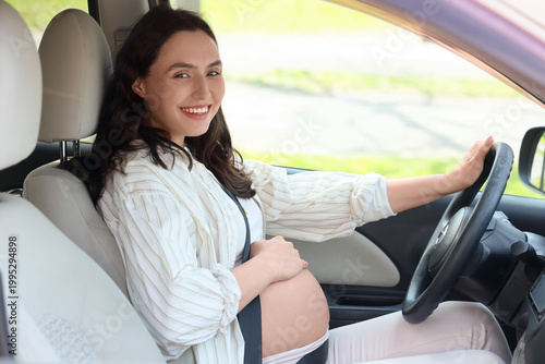Young pregnant woman drivin...