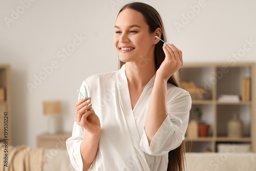 Young woman cleaning ears w...
