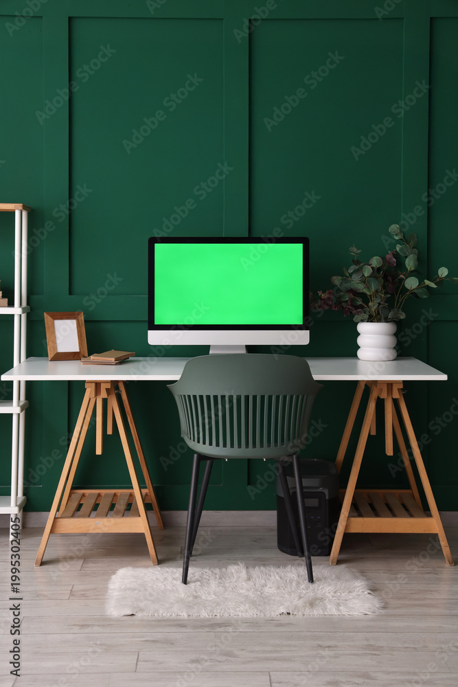 Fototapeta premium Modern workplace with computer near green wall in room