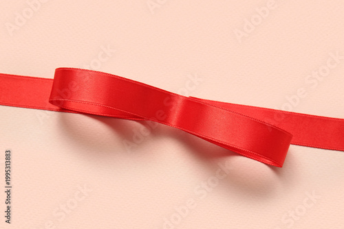 Red satin ribbon on pink ba...