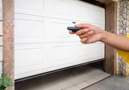 Garage door PVC. Hand use remote controller for closing and opening garage door
