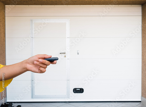 Garage door PVC. Hand use remote controller for closing and opening garage door
