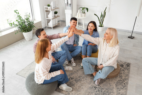 People on poufs giving each...