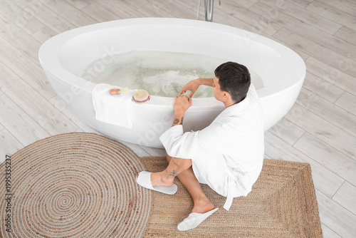Young man running bathtub w...