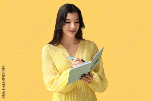 Pretty young woman writing ...