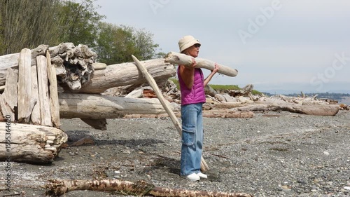 Woman exercises in nature. Lifting logs on the beach.