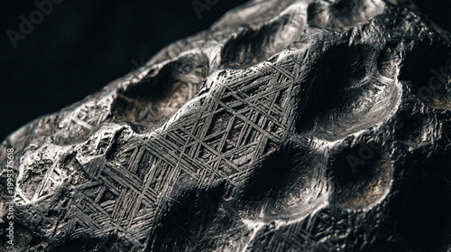 Iron meteorite with Widmanstätten pattern macro shot against black background