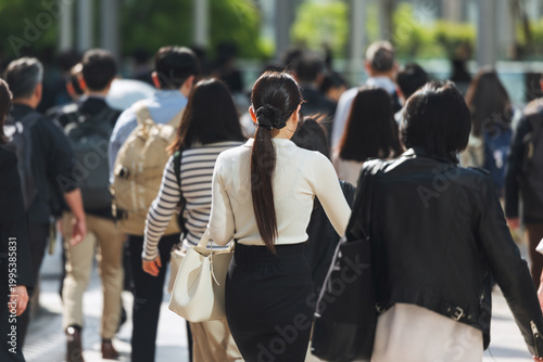 朝、出勤する若い女性の後ろ姿