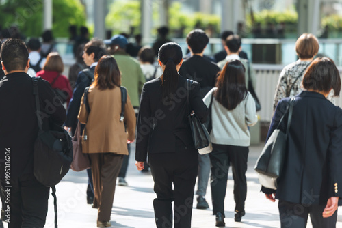 朝、出勤する若い女性の後ろ姿