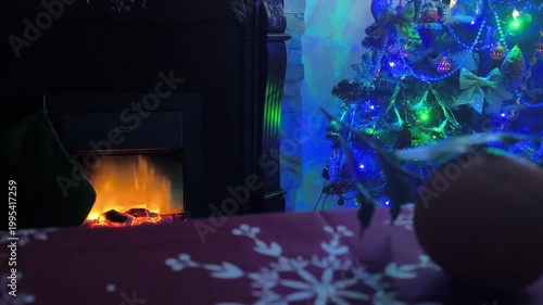 New Year's table with a fireplace and a New Year's tree in the background in the dark
