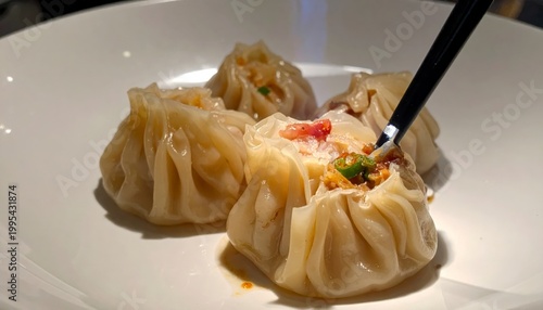 Steaming Xiao Long Bao soup dumplings served on a ceramic spoon with delicate wrappers and savory filling