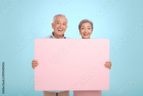 空白のプラカードを持つ日本人の高齢夫婦 マーケティングと販促イメージ