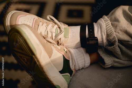 Foto Close up of adult wearing electronic ankle monitor while sitting indoors, representing house arrest, juvenile justice, surveillance