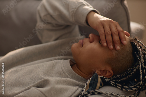 Bilde på lerret Close up of young adult woman resting on sofa, covering forehead and coping with stress during house arrest