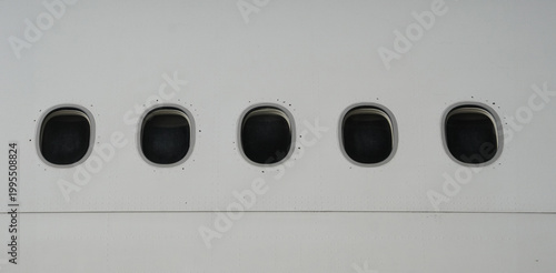 Foto Three commercial airplane windows in a row on white fuselage exterior side profi