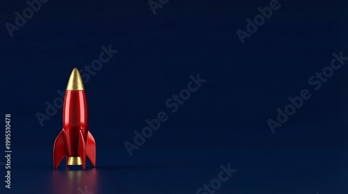 Red toy rocket ship with gold nose cone standing on dark blue background