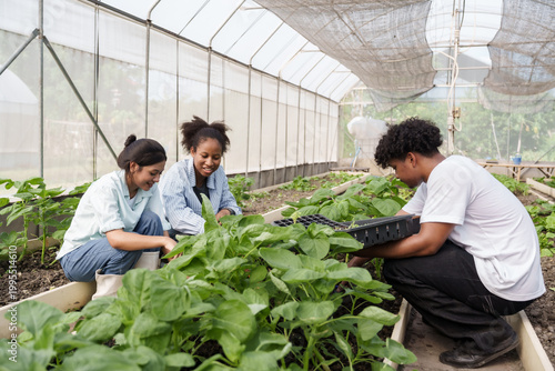 Quadro su tela Group of multiracial students sitting in organic greenhouse learning agriculture