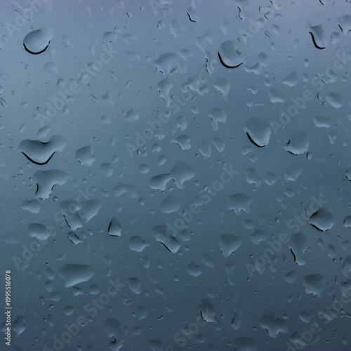 A square close up image of water droplets condensing on glass
