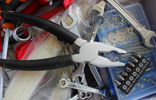 Pliers, Wrenches, Screwdrivers and Screw Bits Chaotically Scattered In Domestic Hardware Box 
