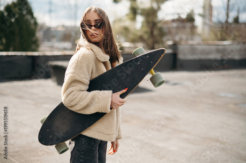 Young Woman with Skateboard on Rooftop