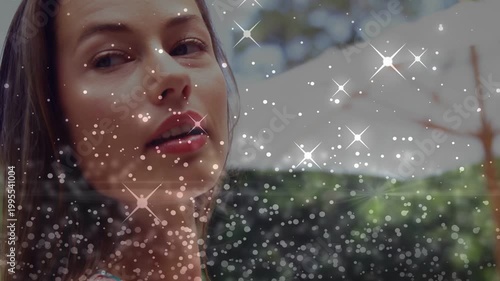 Woman turning left to camera on start, sparkle overlay moving across face, forming marketing clip