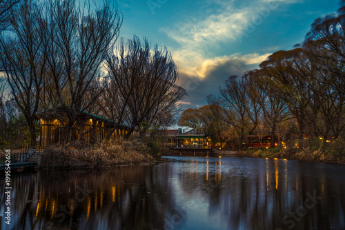 Wooden cabin by the lakeshore at dusk with tranquil waterscape