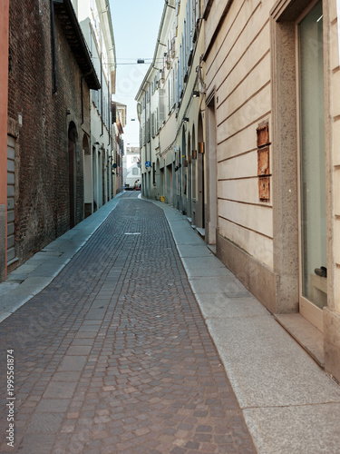 Narrow cobblestone street between historic buildings in Italian city