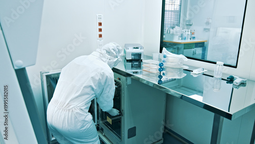 Quadro su tela A researcher, dressed in a clean suit, meticulously handles equipment in a sterile laboratory, highlighting the precision and care essential in healthcare and medicine