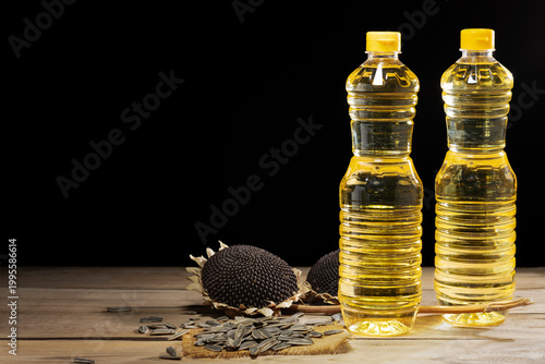 Two bottles of sunflower oil with seeds and dried heads