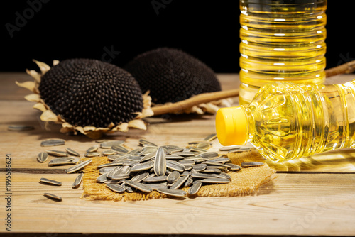 Two bottles of sunflower oil with seeds and dried heads