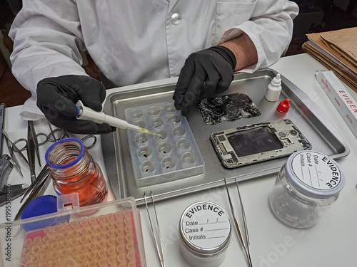 Scientific police extract pieces of burnt smartphone involved in lab murder, concept image