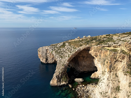 Scenic viewpoint over Blue Grotto, Malta. Natural stone arch and sea caves. Arch window in rock.