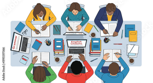 Top down view of diverse students sitting around a large table studying English together with laptops and educational books.