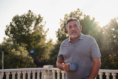Картината върху платно Caucasian mature man enjoying coffee on outdoor terrace