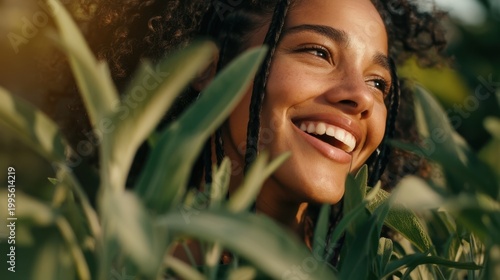 Smiling young woman nature portrait peeking through leaves for wellness banner and outdoor social media background