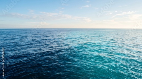 Sea surface extends to the distant horizon under a pale morning sky, showcasing the vast and tranquil nature of the deep blue water that provides a sense of peace and endless space for travel.