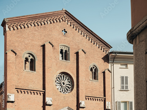 Historic brick church facade with rose window in Piacenza Italy