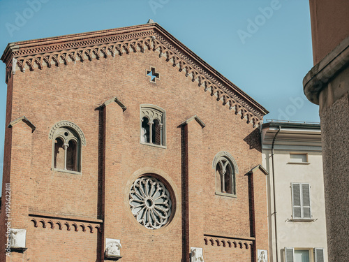 Historic brick church facade with rose window in Piacenza Italy