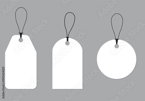 Three blank white tags with black string loops on a gray background