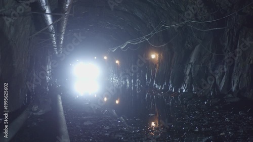 Lights from vehicle illuminating a dark underground mine tunnel